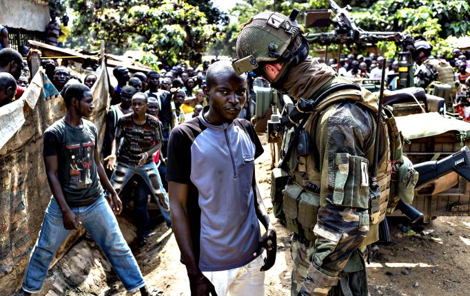 Een man geeft informatie een ex seleka militie aan een franse soldaat in Bangui.